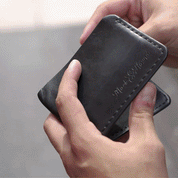 Hand holding AquaVault ChargeCard, showing the product's design and logo.