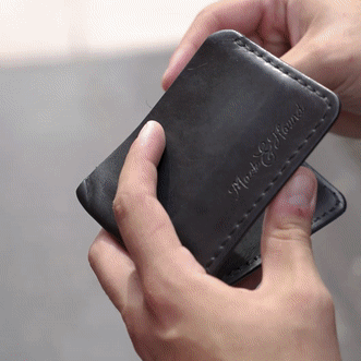 Hand holding AquaVault ChargeCard, showing the product's design and logo.